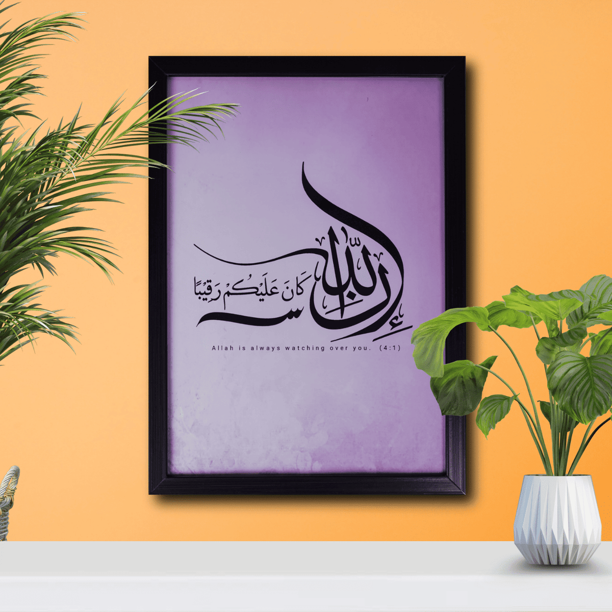 Framed Arabic calligraphy artwork on a purple background with plants on an orange wall.